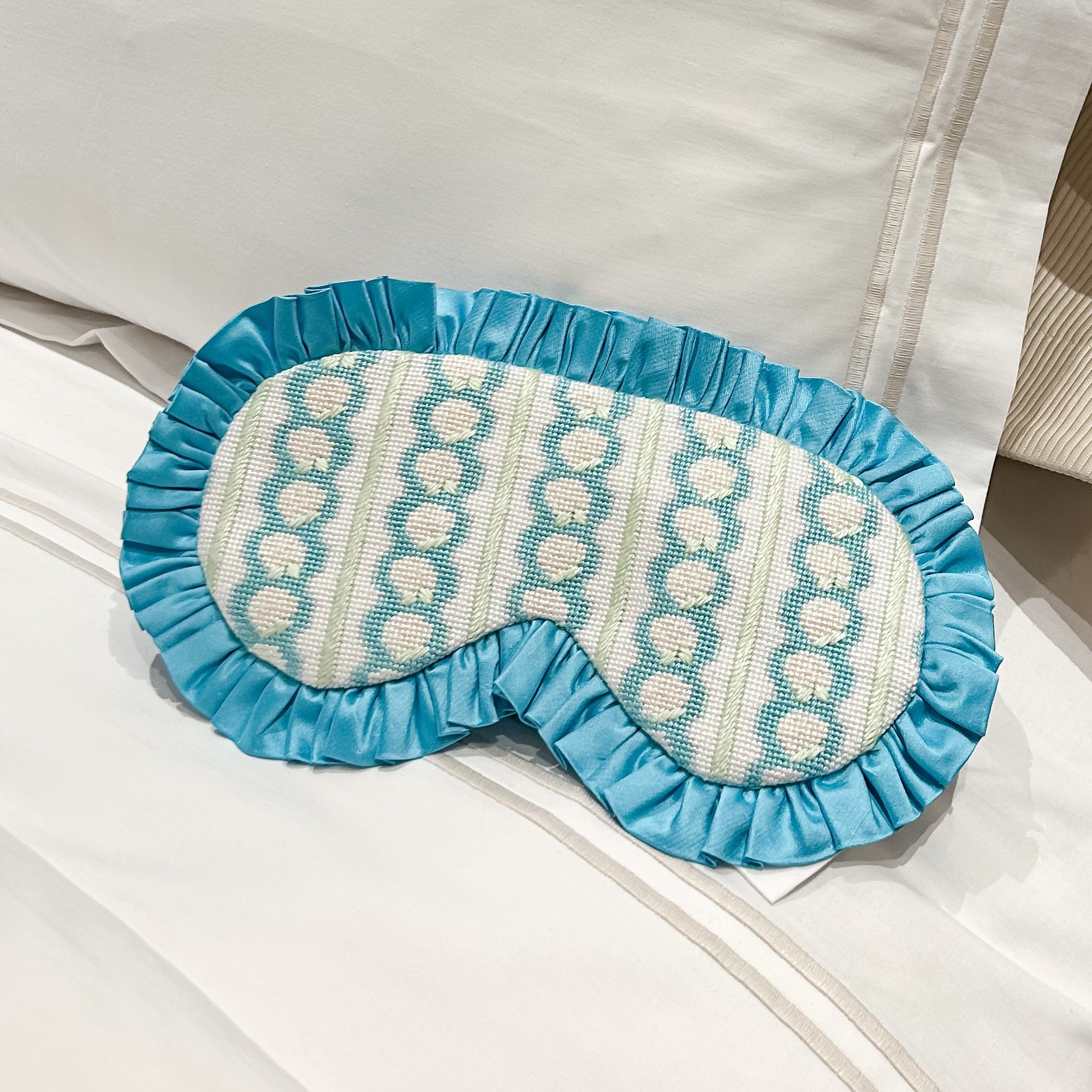 Blue and white hydrangea patterned eye mask on a white pillow